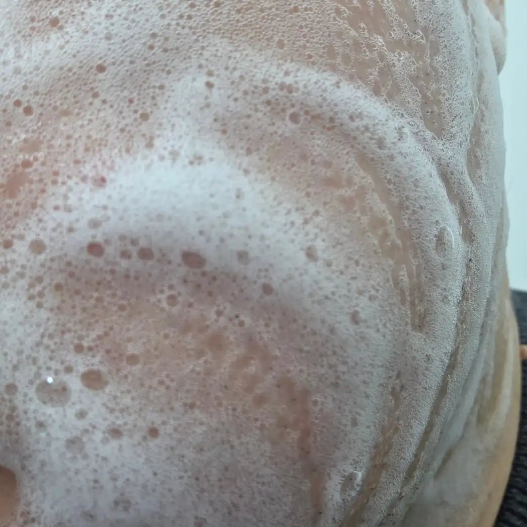Närbild på skummet från SKINØ Cleansing Foam på huden – lätt ansiktstvätt med calendula