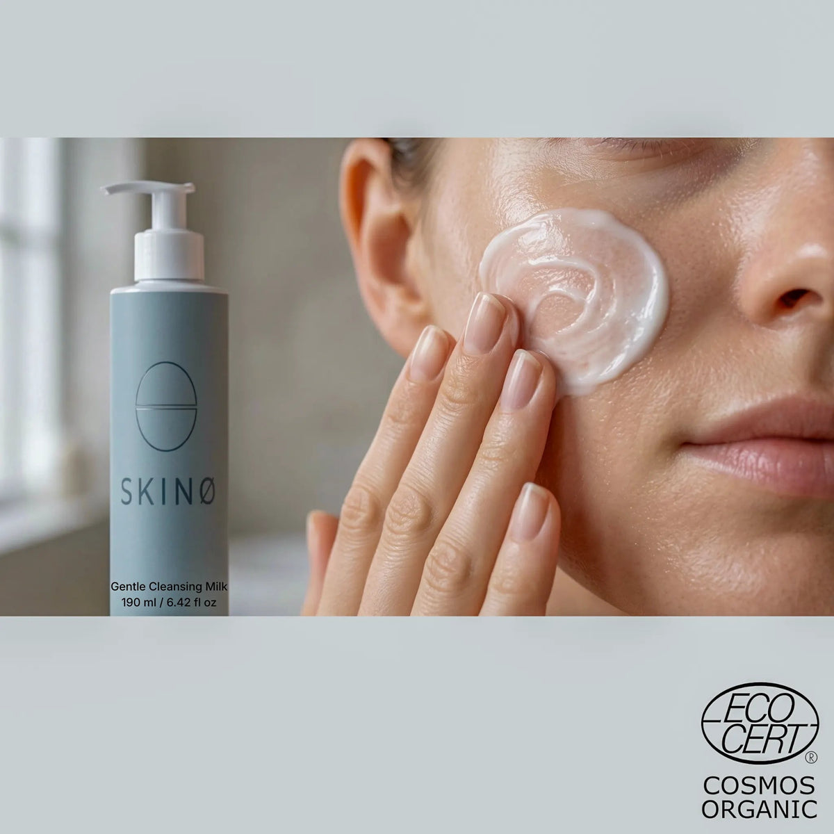 Närbild på vit, silkeslen rengöringsmjölk på kinden bredvid flaskan SKINØ Gentle Cleansing Milk