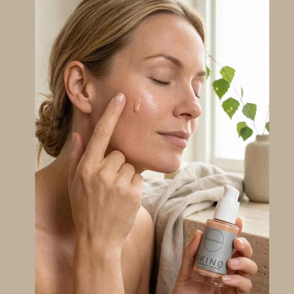 Kvinna applicerar SKINØ Peptide Anti-Aging Serum 30ml – vegansk ECOCERT anti-age hudvård för mogen hud.