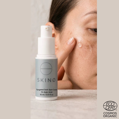 Kvinna applicerar SKINØ Targeted Dark Spot Care på pigmentfläckar i ansiktet – punktbehandling med 1% kojicsyra för jämnare hudton, ECOCERT COSMOS vegansk.